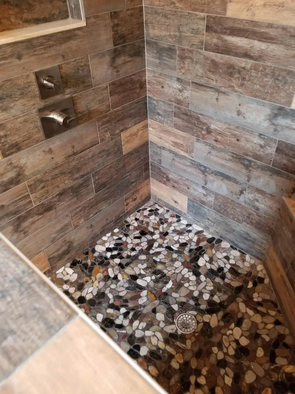 Pebble tile shower floor with the drain set and the pan sloped